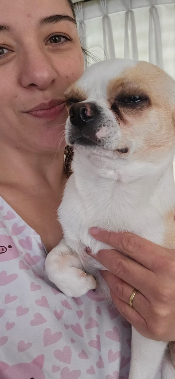 Jésica sonriendo con un chihuahua en brazos